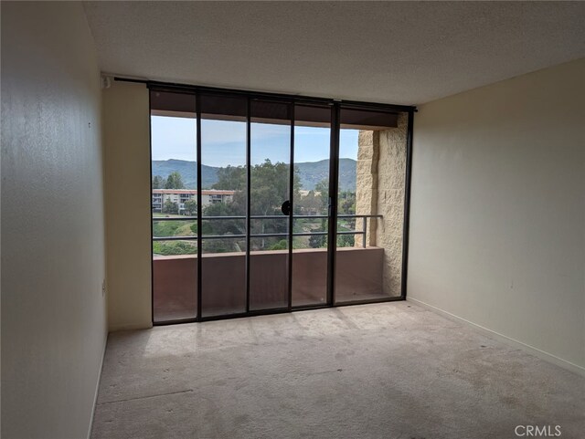 24055 Paseo Del Lago Unit 963, Laguna Woods, CA 92637 - spare room featuring a mountain view, a wall of windows, and carpet flooring