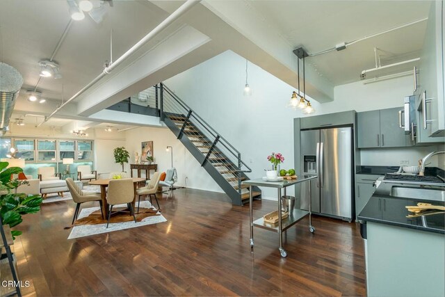 510 S Hewitt St Unit 106, Los Angeles, CA 90013 - dining space with stairs, dark wood-type flooring, track lighting, and a high ceiling