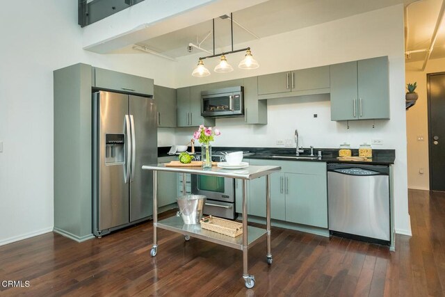 510 S Hewitt St Unit 106, Los Angeles, CA 90013 - kitchen with appliances with stainless steel finishes, dark countertops, dark wood finished floors, and decorative light fixtures