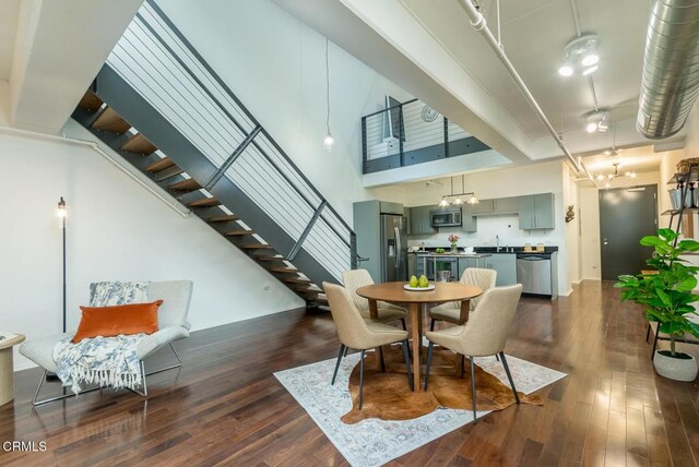 510 S Hewitt St Unit 106, Los Angeles, CA 90013 - dining area featuring stairway, dark wood-style floors, and a high ceiling