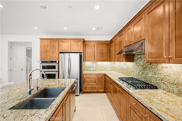 114 Yuba, Irvine, CA 92620 - kitchen with under cabinet range hood, stainless steel appliances, a sink, brown cabinets, and light tile patterned floors