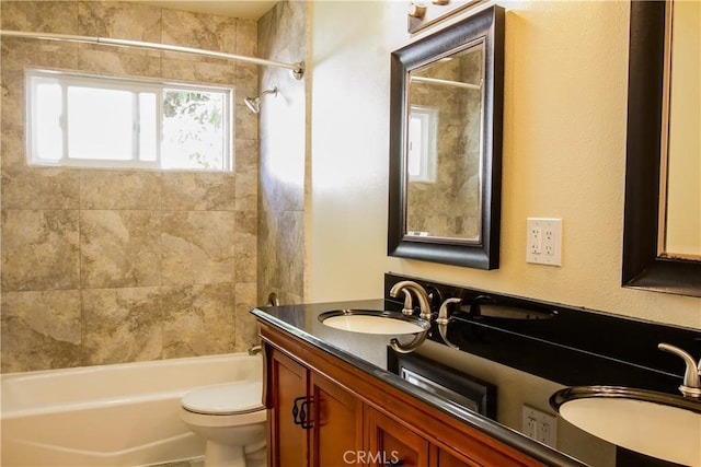 bathroom featuring toilet, double vanity, and shower / bath combination