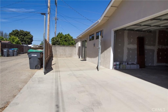 view of patio featuring fence and a garage