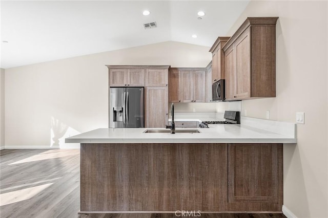 8244 Balsa Ave, Yucca Valley, CA 92284 - kitchen featuring stainless steel appliances, a peninsula, light wood finished floors, light countertops, and vaulted ceiling