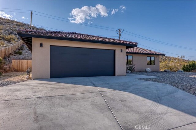 8244 Balsa Ave, Yucca Valley, CA 92284 - mediterranean / spanish house featuring a tile roof, stucco siding, driveway, and an attached garage