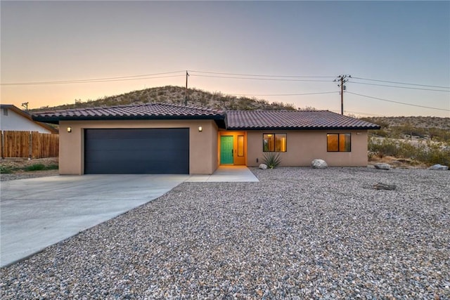 8244 Balsa Ave, Yucca Valley, CA 92284 - view of front of property featuring an attached garage, driveway, stucco siding, and a tile roof