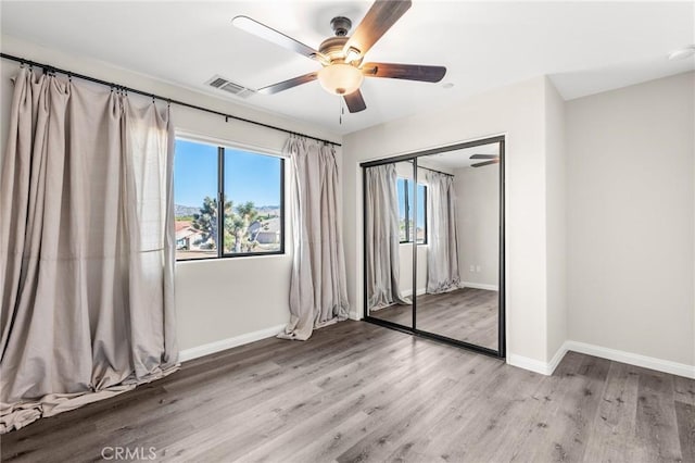 8244 Balsa Ave, Yucca Valley, CA 92284 - unfurnished bedroom with wood finished floors, ceiling fan, and a closet