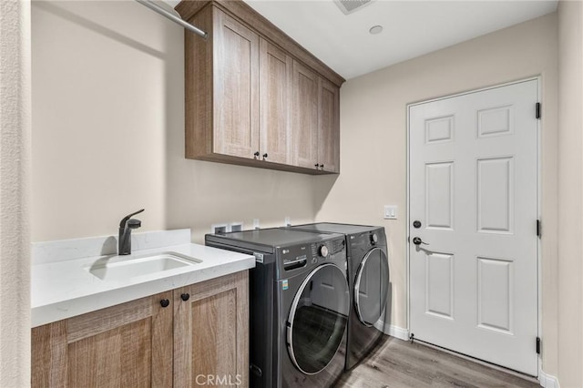 8244 Balsa Ave, Yucca Valley, CA 92284 - laundry area with cabinet space, washing machine and dryer, light wood finished floors, and baseboards