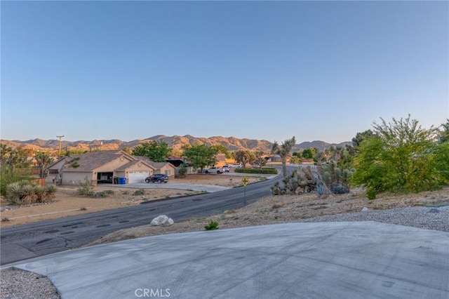 8244 Balsa Ave, Yucca Valley, CA 92284 - view of yard featuring an attached garage, a mountain view, and concrete driveway