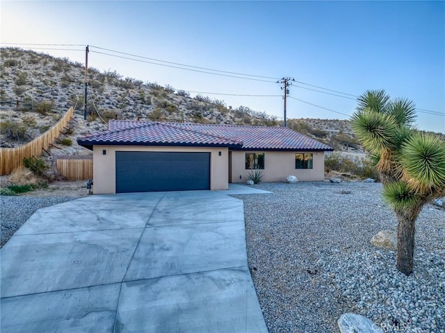 8244 Balsa Ave, Yucca Valley, CA 92284 - view of front of house with a tile roof, driveway, an attached garage, and stucco siding