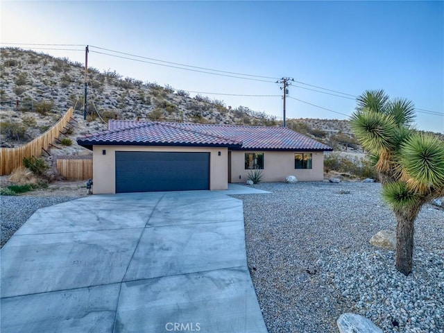 8244 Balsa Ave, Yucca Valley, CA 92284 - view of front of house with a tiled roof, concrete driveway, an attached garage, and stucco siding