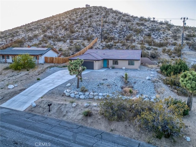 8244 Balsa Ave, Yucca Valley, CA 92284 - view of front of house with a mountain view, an attached garage, driveway, and a tile roof