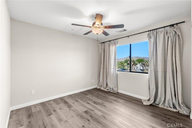 8244 Balsa Ave, Yucca Valley, CA 92284 - empty room featuring wood finished floors, a ceiling fan, and a mountain view