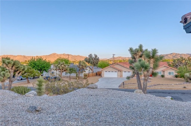 8244 Balsa Ave, Yucca Valley, CA 92284 - view of front of house featuring a mountain view, a detached garage, and driveway