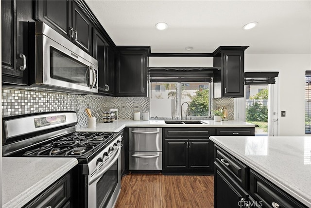 356 Freedom, Upland, CA 91786 - kitchen featuring appliances with stainless steel finishes, dark cabinetry, a sink, dark wood-type flooring, and backsplash