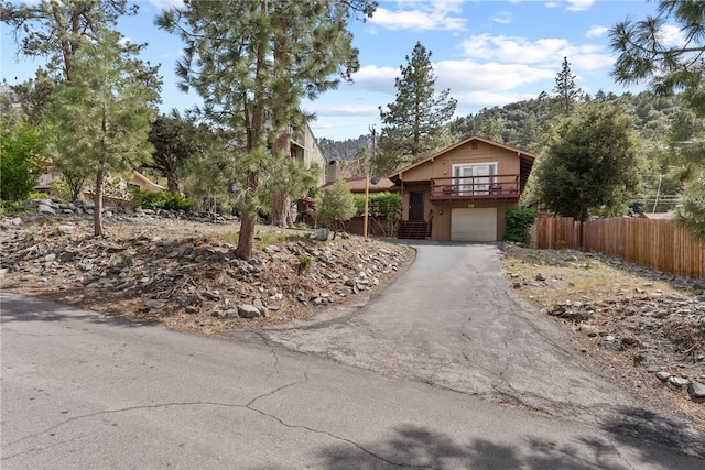 5203 Desert View Dr, Wrightwood, CA 92397 - obstructed view of property featuring asphalt driveway, an attached garage, and fence