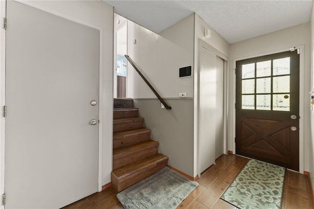 5203 Desert View Dr, Wrightwood, CA 92397 - foyer entrance with light wood-style flooring, stairs, a textured ceiling, and baseboards