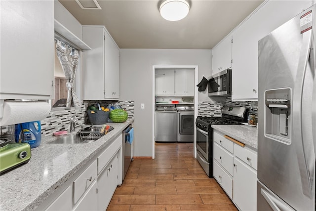 5203 Desert View Dr, Wrightwood, CA 92397 - kitchen featuring appliances with stainless steel finishes, separate washer and dryer, a sink, tasteful backsplash, and white cabinets