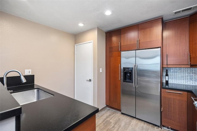 81 Cloudcrest, Aliso Viejo, CA 92656 - kitchen with stainless steel fridge with ice dispenser, dark countertops, light wood-style flooring, recessed lighting, and brown cabinets