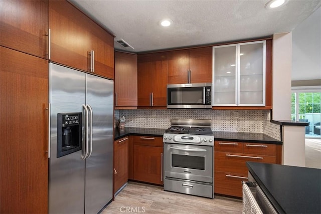 81 Cloudcrest, Aliso Viejo, CA 92656 - kitchen with appliances with stainless steel finishes, dark countertops, decorative backsplash, glass insert cabinets, and recessed lighting