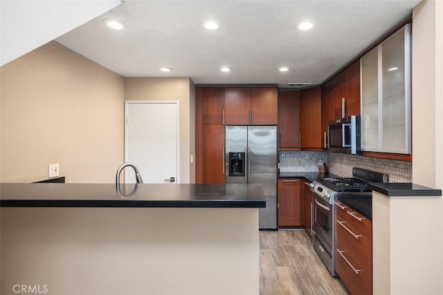 81 Cloudcrest, Aliso Viejo, CA 92656 - kitchen featuring appliances with stainless steel finishes, dark countertops, light wood-style floors, recessed lighting, and backsplash
