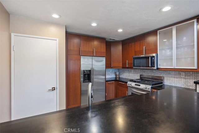 81 Cloudcrest, Aliso Viejo, CA 92656 - kitchen featuring appliances with stainless steel finishes, dark countertops, backsplash, glass insert cabinets, and recessed lighting