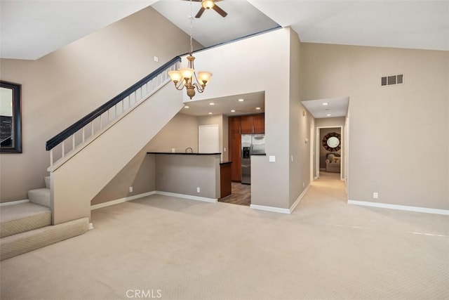 81 Cloudcrest, Aliso Viejo, CA 92656 - unfurnished living room with light colored carpet, ceiling fan, a towering ceiling, stairs, and a chandelier