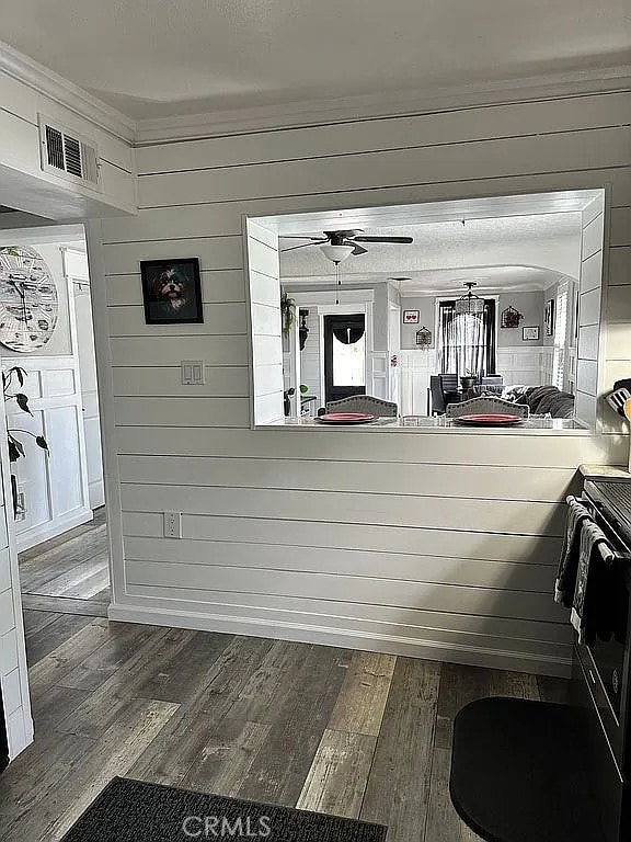 bathroom with wood finished floors, crown molding, and ceiling fan