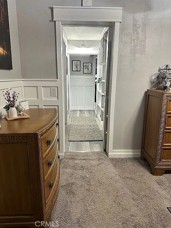 hallway featuring a decorative wall and carpet