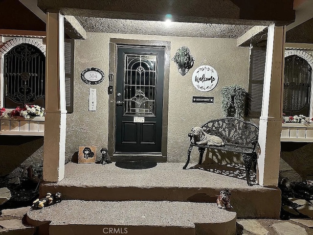 view of exterior entry featuring covered porch