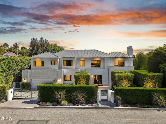 1116 Linda Flora Dr, Los Angeles, CA 90049 - contemporary home with a gate, stucco siding, an attached garage, driveway, and a chimney