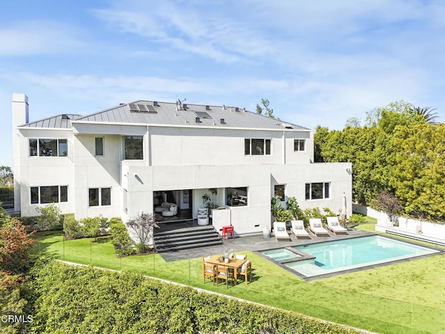 1116 Linda Flora Dr, Los Angeles, CA 90049 - back of property with a patio, a standing seam roof, a yard, a pool with connected hot tub, and stucco siding