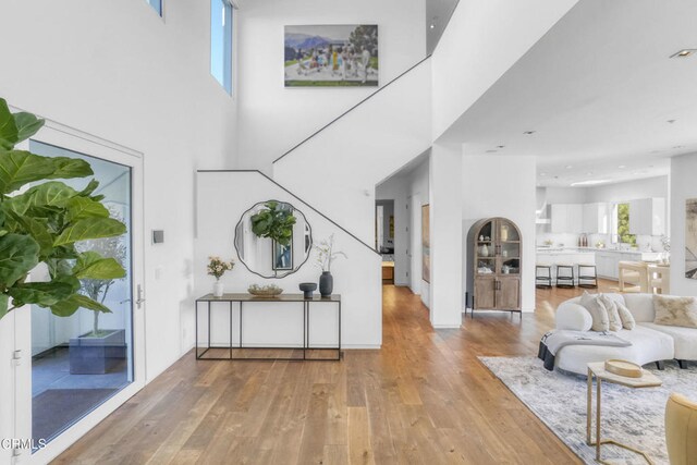 1116 Linda Flora Dr, Los Angeles, CA 90049 - foyer entrance featuring hardwood / wood-style floors, a towering ceiling, and stairs