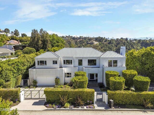 1116 Linda Flora Dr, Los Angeles, CA 90049 - view of front of house with a gate, stucco siding, a standing seam roof, and driveway