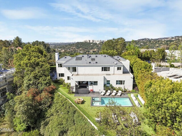 1116 Linda Flora Dr, Los Angeles, CA 90049 - back of house with stucco siding, a patio area, metal roof, a standing seam roof, and a pool with connected hot tub