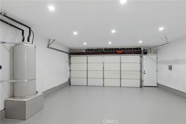 garage with water heater, recessed lighting, and baseboards