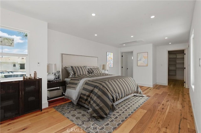 bedroom with light wood-type flooring, recessed lighting, multiple windows, and baseboards