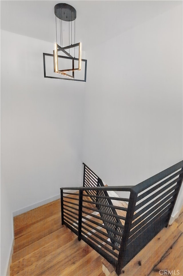 staircase featuring wood finished floors and baseboards