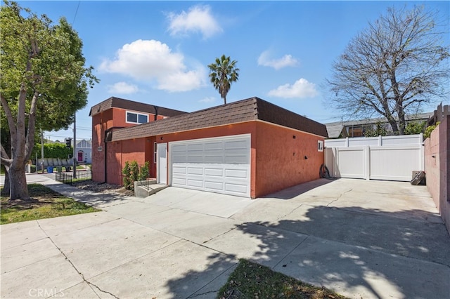 view of property exterior featuring fence, roof with shingles, stucco siding, and driveway
