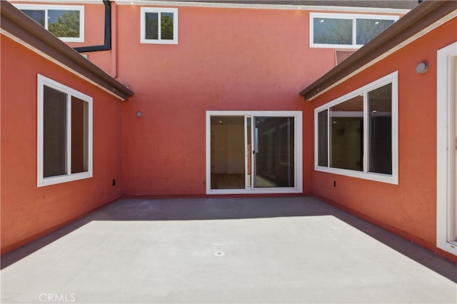 rear view of property with a patio and stucco siding