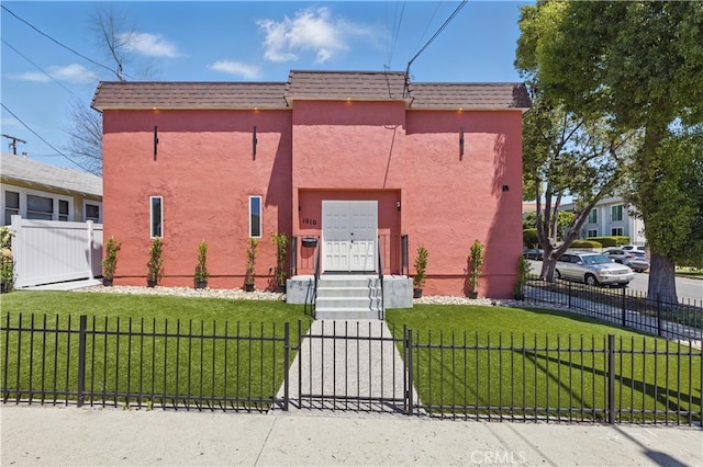 view of front of house featuring stucco siding, mansard roof, and a gate