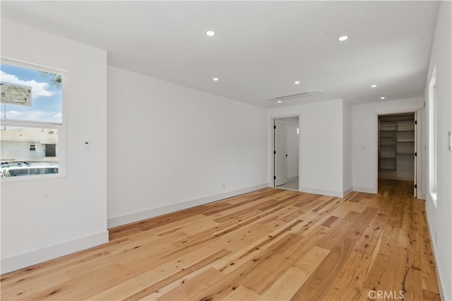 empty room featuring recessed lighting, light wood finished floors, and baseboards