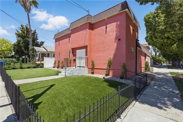 view of front of property with stucco siding and mansard roof