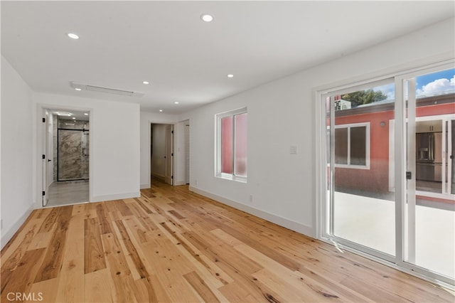 empty room featuring recessed lighting, light wood finished floors, and baseboards