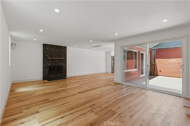 unfurnished living room featuring light wood-style floors, recessed lighting, a fireplace, and baseboards