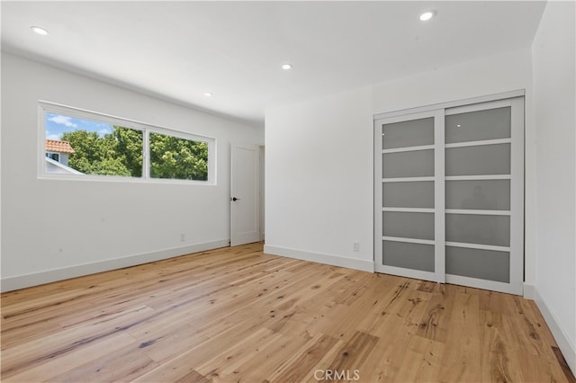unfurnished room featuring light wood-type flooring, recessed lighting, and baseboards