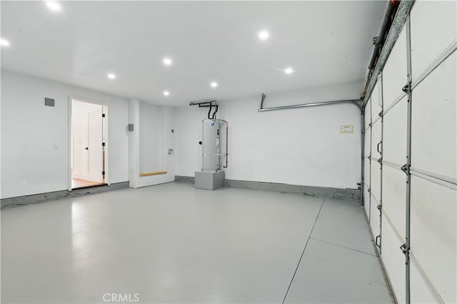 garage featuring recessed lighting, water heater, and baseboards