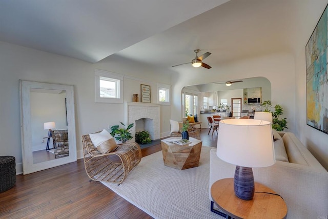 487678 34th St, San Diego, CA 92116 - living area featuring arched walkways, a ceiling fan, wood finished floors, and a brick fireplace