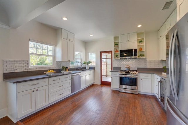 487678 34th St, San Diego, CA 92116 - kitchen featuring appliances with stainless steel finishes, open shelves, dark countertops, decorative backsplash, and recessed lighting