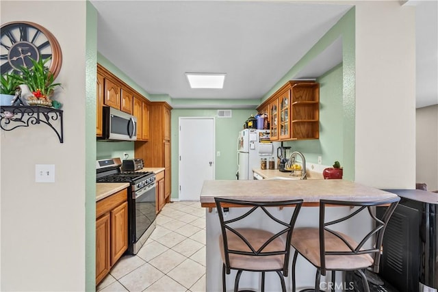 11483 Green Vly, Pacoima, CA 91331 - kitchen with stainless steel appliances, a sink, a breakfast bar area, open shelves, and light countertops